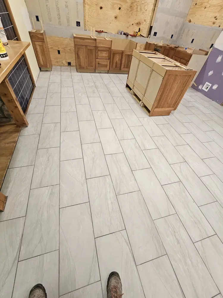 Large-format porcelain tile floor installed around new cabinets