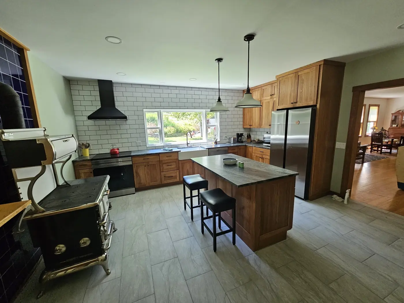 Remodeled kitchen with cherry cabinets, subway tile, island and farmhouse sink