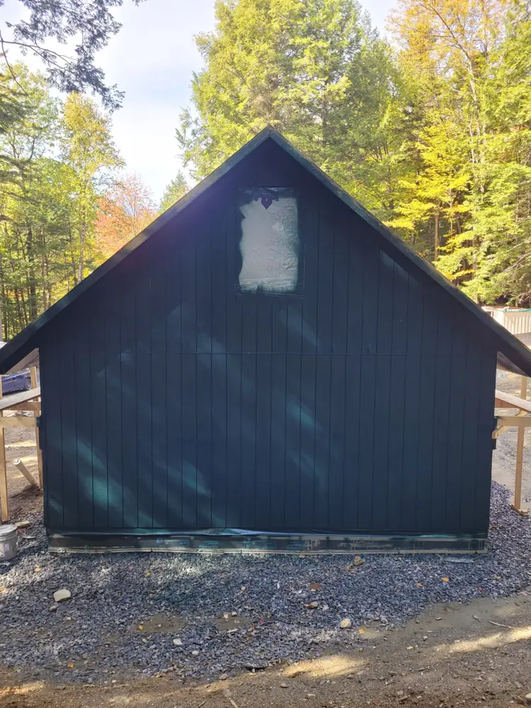 Gable end with vertical siding painted dark green